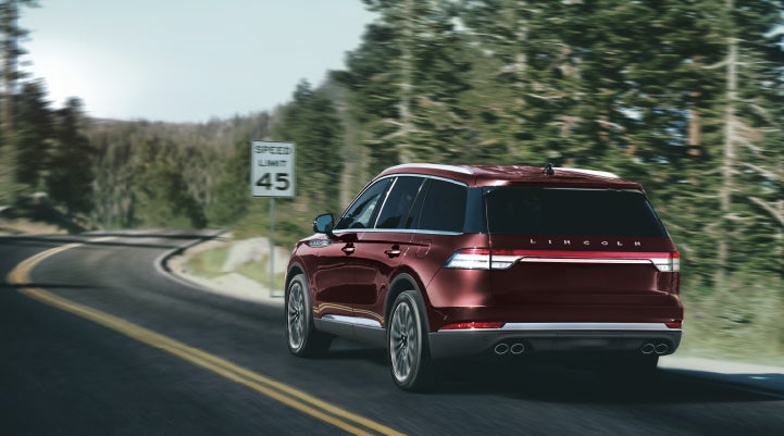 A 2024 Lincoln Aviator® SUV is being driven on a winding mountain road | Vance Lincoln in Miami OK